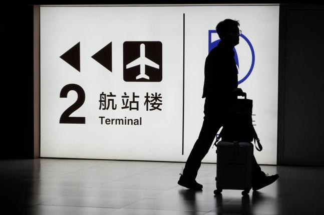FILE - A passenger arrives at the Capital Airport in Beijing on Nov. 7, 2025. (AP Photo/Ng Han Guan, file)