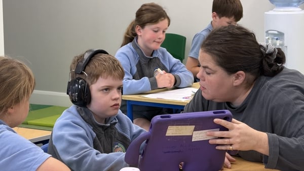 A child looks at a tablet in a school room